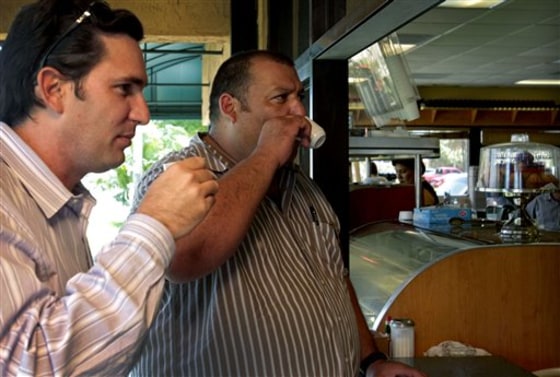 Cuban-Americans Frank Baruas, left, and Carlos Cuenca, right, enjoy a Cuban coffee at the Latin American Grill in Miami, Thursday, July 28, 2011. A growing number of Cuban-Americans are worried about the U.S. reinstating strict limits on how often they can visit relatives and even how much money can be sent home to loved ones in the communist nation.